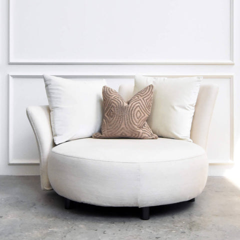 Paramour round cream sofa with beige throw pillow, perfect for a spacious airy living room design.
