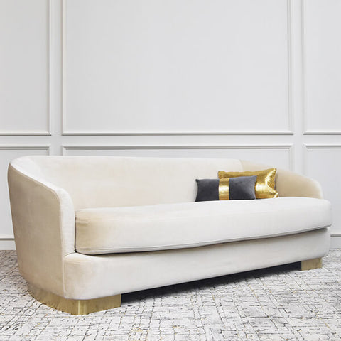 Angled view of the Rever Curved sofa, 3 seater, modern mid-century design. Style this deep sofa with the Mesh gold boudoir cushion, matching the brushed gold steel legs.