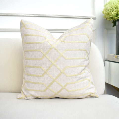 Atticus Embroidery Square Cushion, Linen Gold Beige sitting on Ivory sofa edge.
