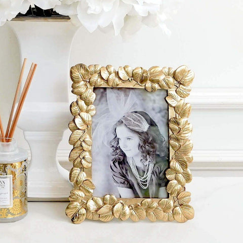 Gold leaves adorns the edges of the photo frames in a rustic gold finish.