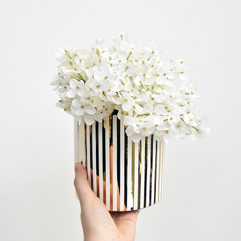 White and Gold striped round planter with flowers.