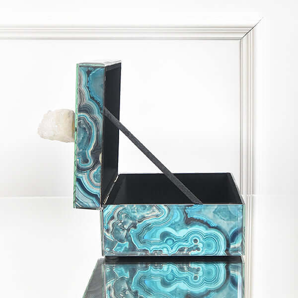 Side view of open glass box with intricate marble swirls.