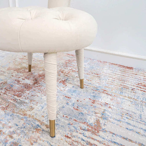 Zoomed in tufted ivory accent chair with gold tip feet.