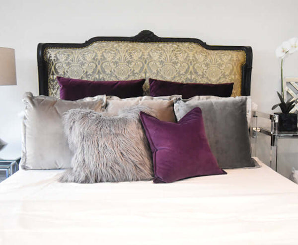Bedroom decor home ideas with deep purple velvet cushion and furry cushions.