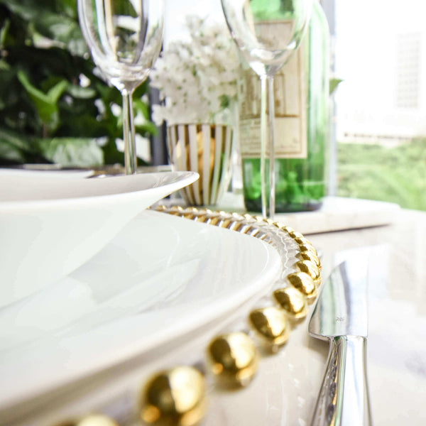 Dining table set up with dining wear deco, white and gold.