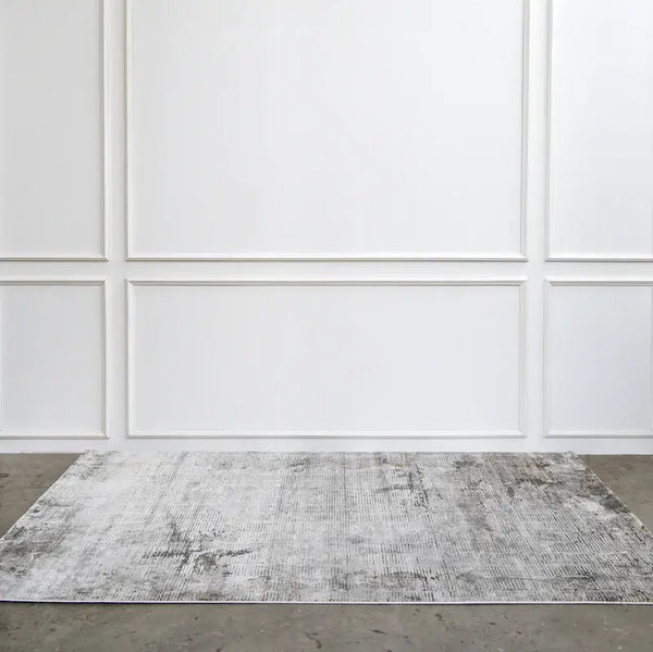 Side full view of the grey hues on the Bastien rug on flooring.