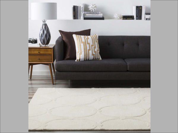 Crerate a contracting look with a light rug against a dark sofa.