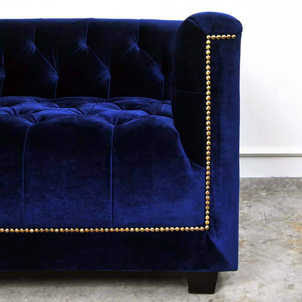 Zoom in details of Nail head trim lines front of sofa on Luxurious Blue Velvet.
