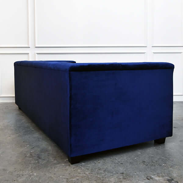 Back view of modern vintage 3-seater Chesterfield sofa with plush smooth velvet upholstery.