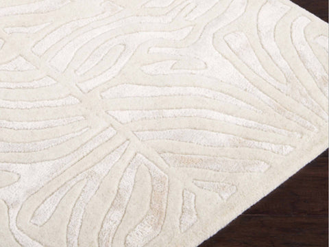 Hand-tufted of New Zealand wool, this Candice Olson plush rug exudes true art form with carved details of unique maze pattern in shades of ivory.