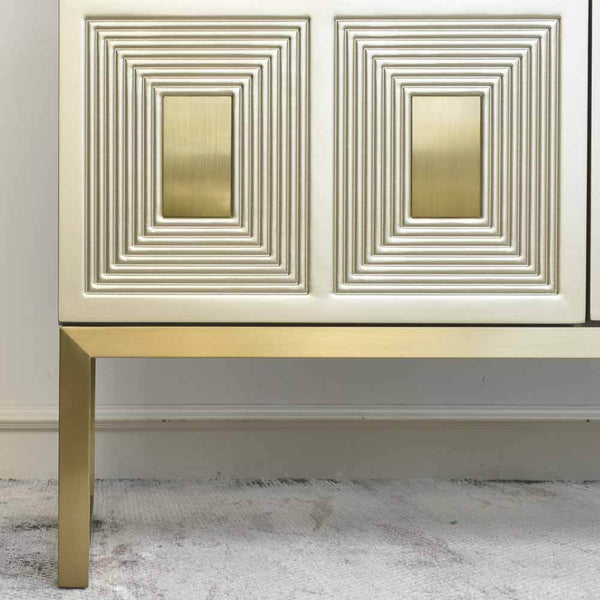 Zoom in view of the door panel details of the 2 Door Contratto Cabinet, brushed gold legs, rectangular panels with brush gold inner.  