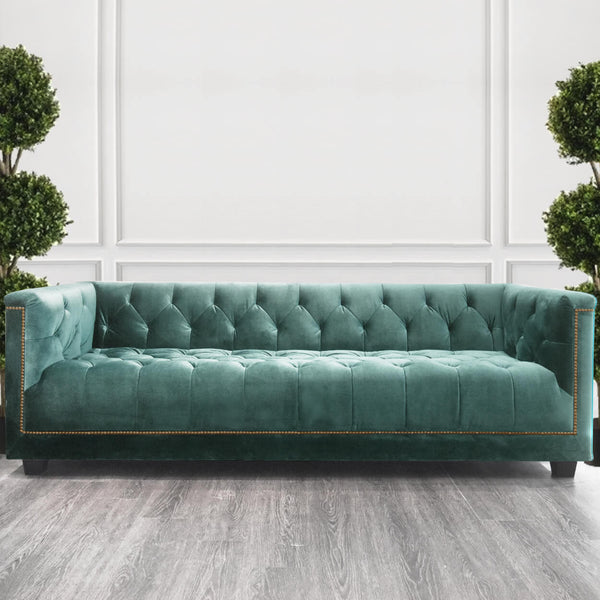 The Earl sofa in soft teal upholstery, offering a refreshing, modern tone with hand-tufted detailing.
