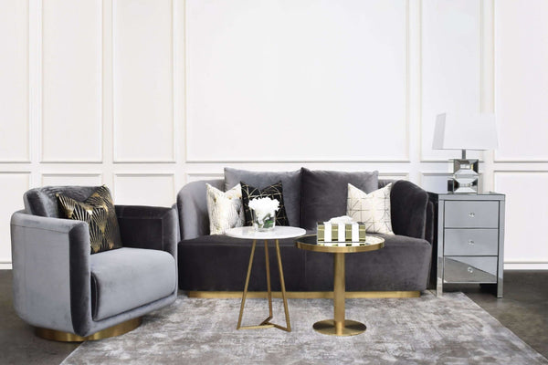 Beautifully styled modern luxury living room featuring the Zelda curved grey velvet sofa with matching armchair, elegant coffee table, side table, and coordinated throw pillows for a refined, cohesive look.