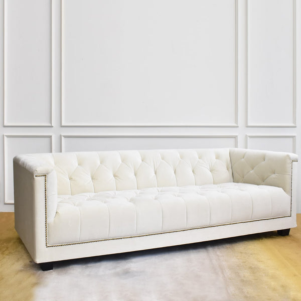 Side profile of the Earl & Duchess sofa in ivory cream upholstery, showcasing its silhouette and tufted arm detail.