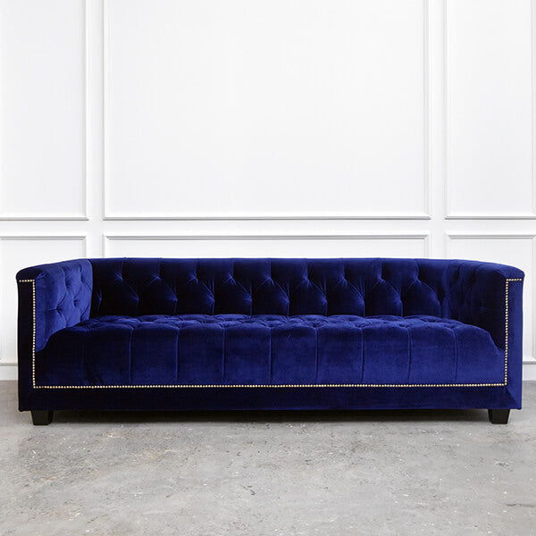 Earl sofa shown in rich indigo upholstery, highlighting the plush velvet and hand-tufted surface.