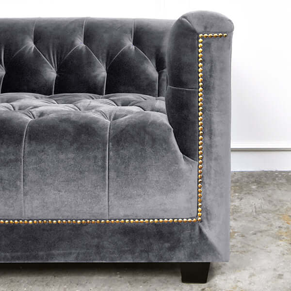 Close-up of the sofa’s front edge, focusing on the intricate nail head trim along the base.