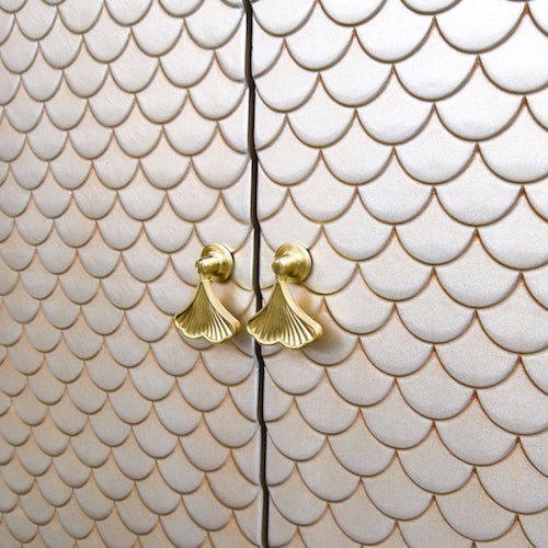 Features gold winged Cabinet handles and mermaid scale like patterns on door.