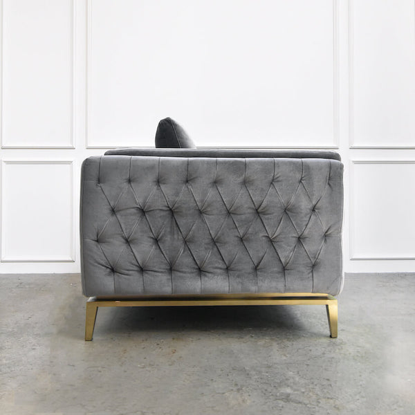 Side view of hand-tufted sofa, 3-seater, grey velvet, gold base frame.