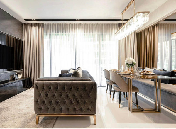 Grey leather Fitzgerald sofa in a luxurious living room with open dining area behind.