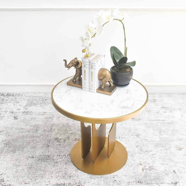 Hilltops Marble Coffee Table is decorated with elephant bookends and orchid plant for a modern living room design.
