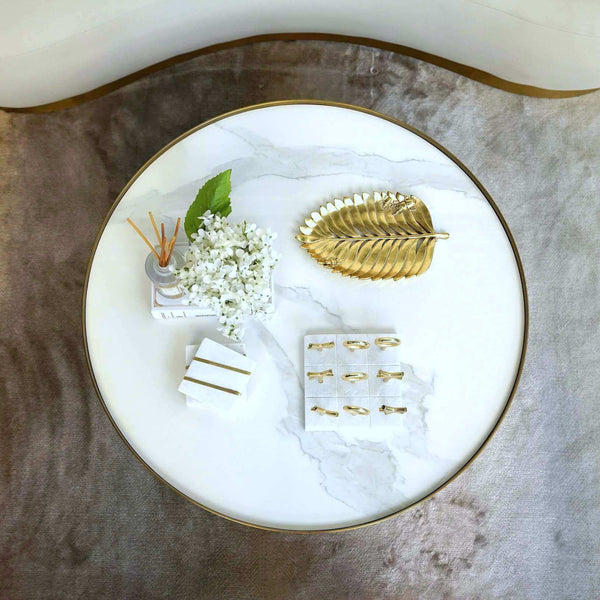 White Marble Coffee Table Decor Display with Gold Leaf Tray and Decor from Finn Avenue. Center this round coffee table against a curved sofa for the ultimate sleek look.