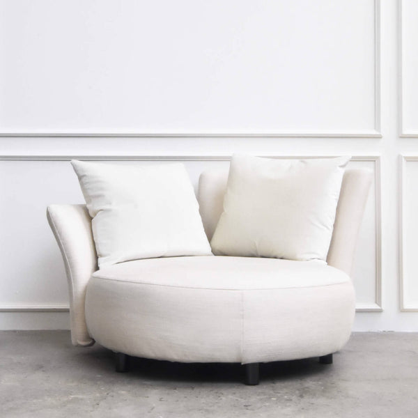 Front view of the Paramour Round Sofa showcasing its curved form, plush seat, and two oversized back pillows.