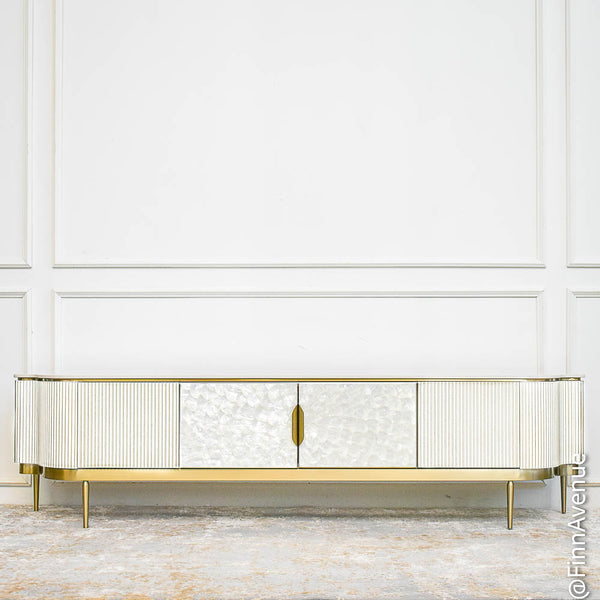 Perla white wood TV console with mother-of-pearl inlay and brushed gold legs in an airy, white and gold luxury living room.