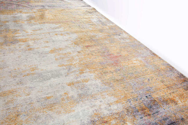 Provence Luxury rug on the floor, varying hues of gold from different angles.