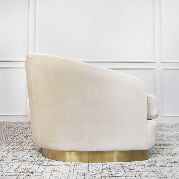 Side view of the Rever sofa, angled corners sloping from the back to the armrest. Solid stainless steel gold base.