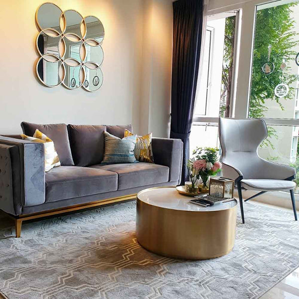 The stylish FItzgerald Sofaand Marc Coffee Table coupled with home accessories Circle of Life Mirror and Quinn Rug showcase comfortable, affordable luxury in the modern living room of the high-end condo in Singapore.