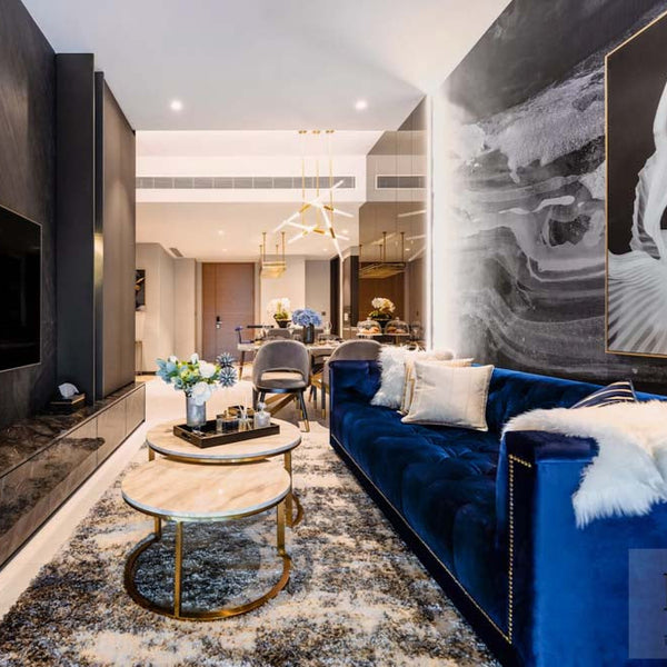 The timeless blue Countess Chesterfield Sofa from Finn Avenue, featured with decorative cushions anchors a luxurious living room in Singapore. This affordable luxury sofa is beautifully paired with a luxury rug, throw cushions designed by Singapore's Mr Shopper Studio showcasing a sophisticated design.