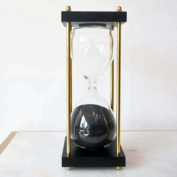 Black wooden base with black sand and gold stands around.