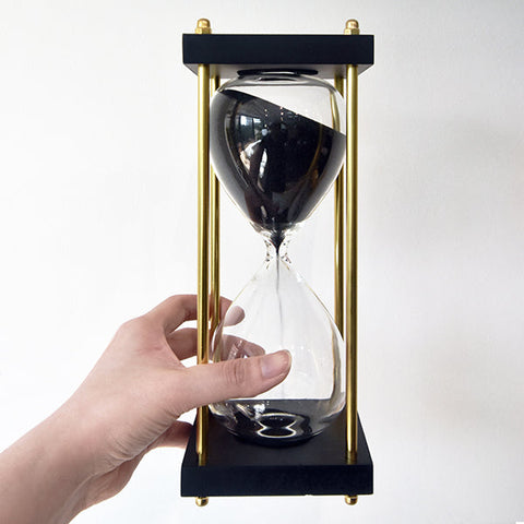Hand holding Hourglass with stand.