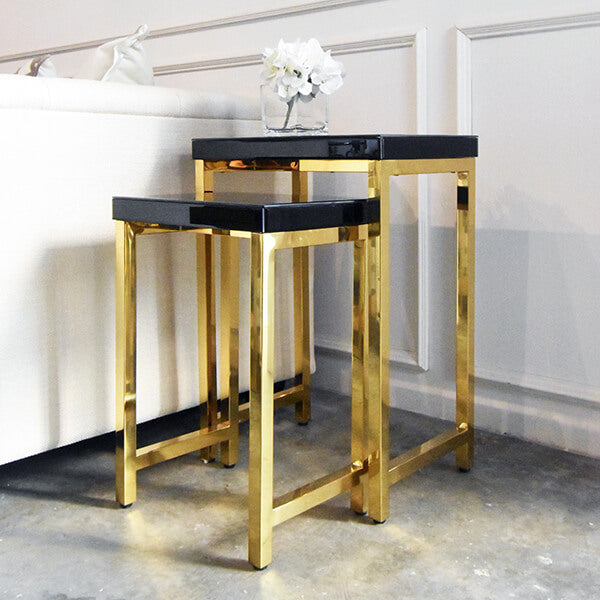Nesting side tables, black glass table top with polished gold legs.