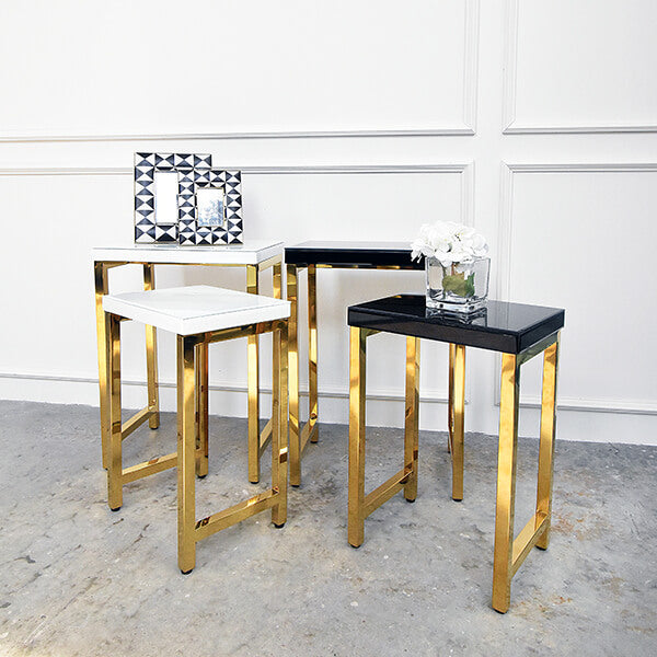 Thierry Nesting table collection, available in white and black with polished gold legs.