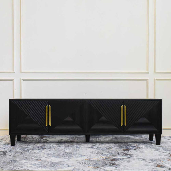 The Uno 4 Door TV console sideboard features a sleek brushed gold handles and slim small solid wood black legs, with geometric hand carved door panels.