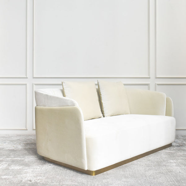 Curved ivory cream velvet sofa with high arms and brushed gold toe kick on a hardwood frame.