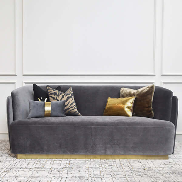 Customizable sofa with a double-curved back and gold-finished base, styled in a modern living room.