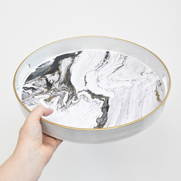 Hand holding Zeus Round Marbled Decor Tray.