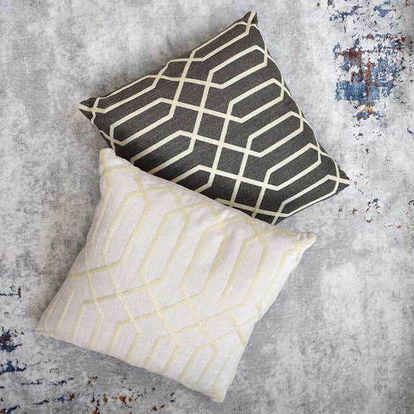 Top view of square cushions in grey and beige options, with golden beige geometric embroidery patterns.