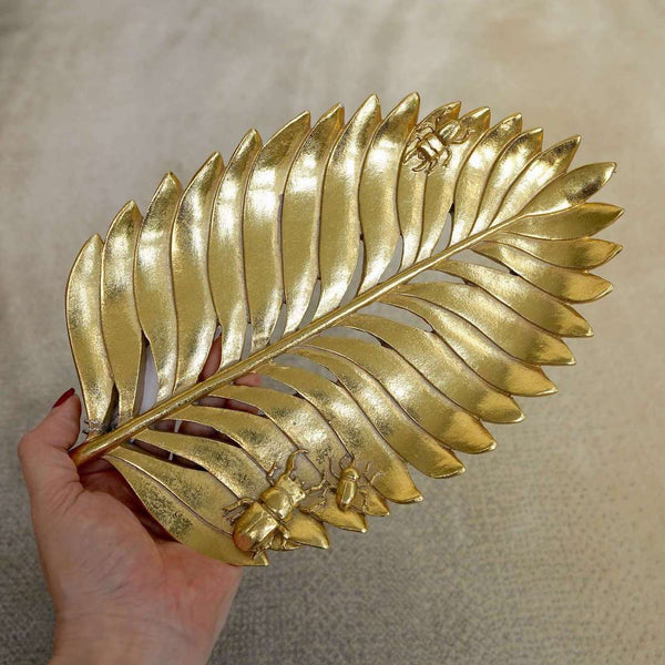 Close up view of Monstera Leaf Sculpture on hand. With insect details on leaf.