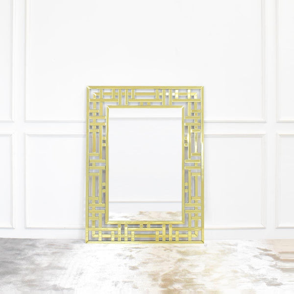 Desiree Gold Wall Mirror with Geometric Wall Art Design displayed Vertically on top of Luxury Rug .