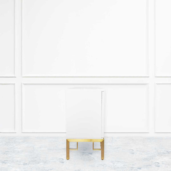 Side view of Ivory TV console with brushed stainless steel gold legs.