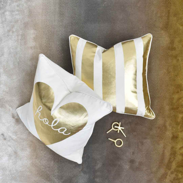 Ivory and gold pillows on rug setting. 