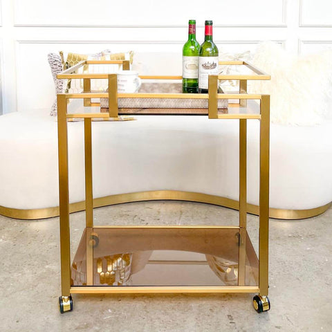 The Nassim bar cart trolley is a statement piece, the tea-tinted glass shelves serves Old Hollywood glamour and style.