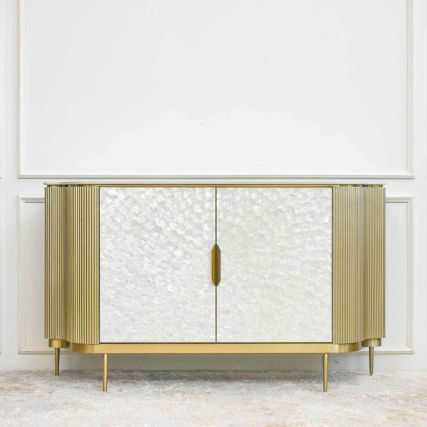 Perla mother-of-pearl sideboard is beautifully juxtaposed by the metallic champagne gold details that highlight the design of the cabinet door handles, legs and structure. 
