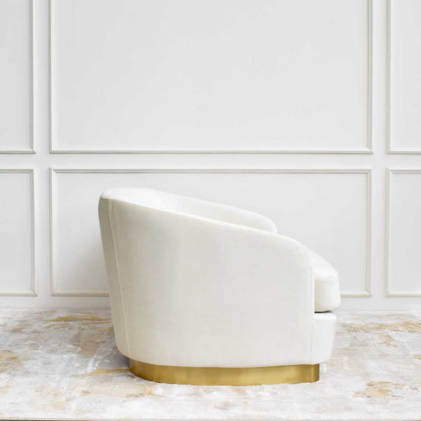 Side angle of the custom upholstered Rever Curved Sofa showcasing its asymmetrical silhouette, recessed gold pedestal base, and sleek profile.