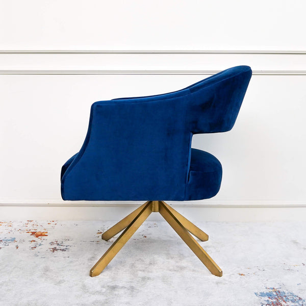 A distinctive velvet cover in a surprising shade of blue while its metal base showcases a touch of metallic gold finish.