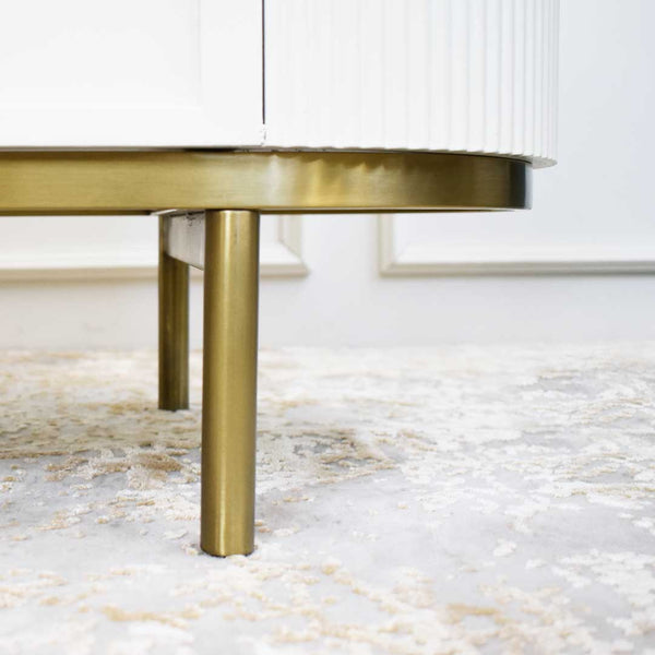 Cabinet with slim gold feet and ivory door fluted panels.
